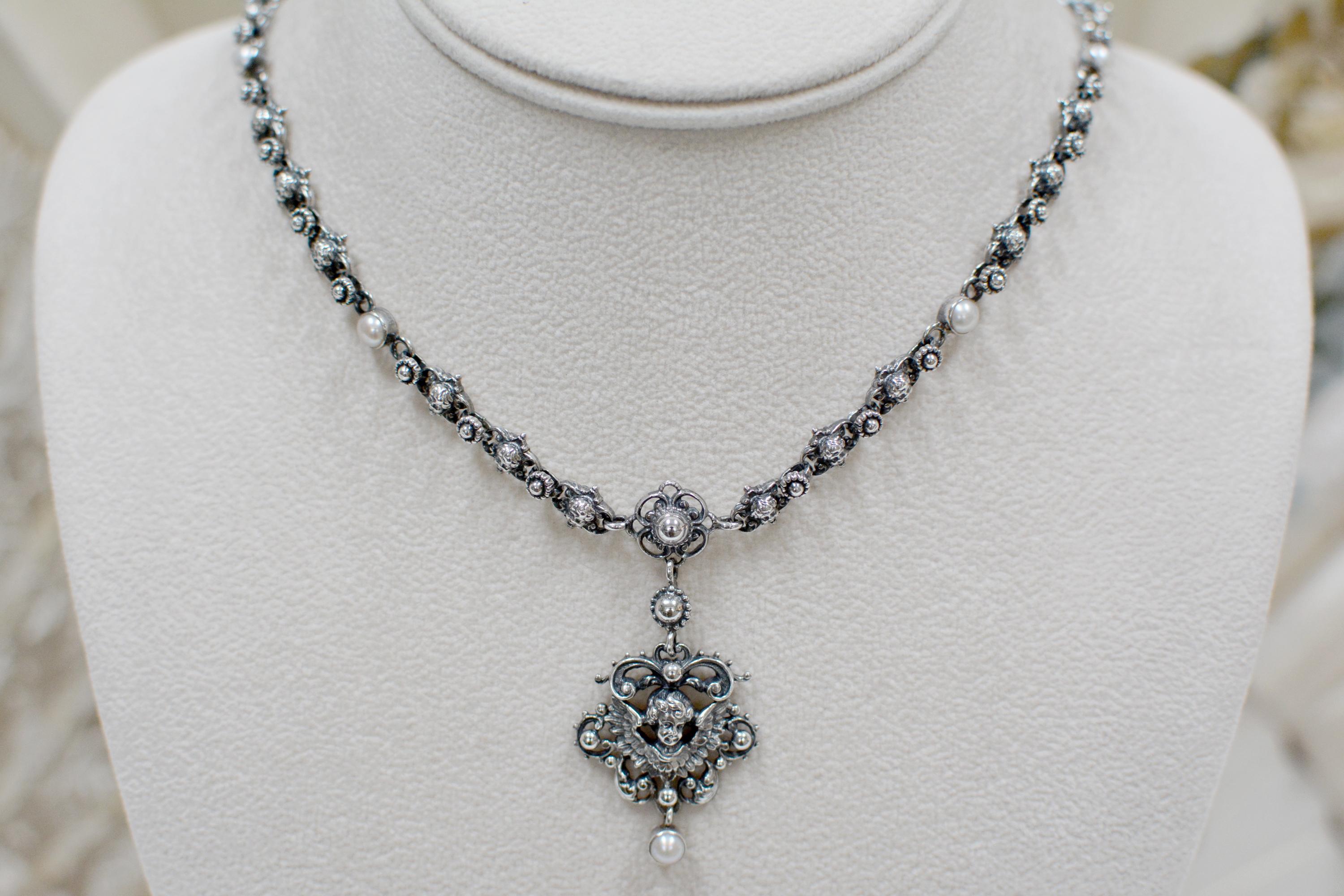 This exquisite original Jill Garber drop necklace is comprised of twenty-eight, very fine figural cherub angel links joined together by delicate sterling silver flower links. This lovely necklace requires extensive hours of hand work to assemble.
