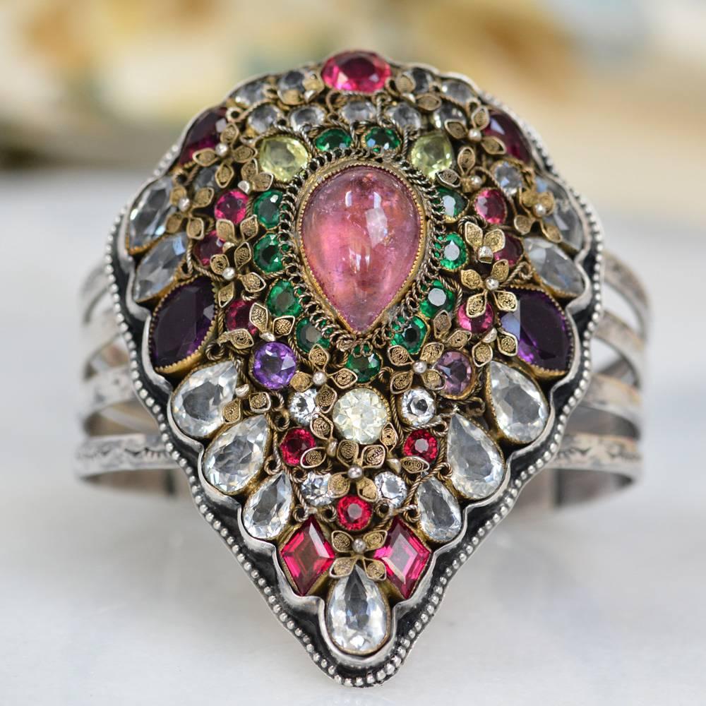 This one of a kind Sterling Silver cuff bracelet features a rare early Hobe' pear shaped brooch having at its center an 8.32 karat pink tourmaline with three natural green peridot. Each outside spine of this exquisite cuff is hand stamped with lace