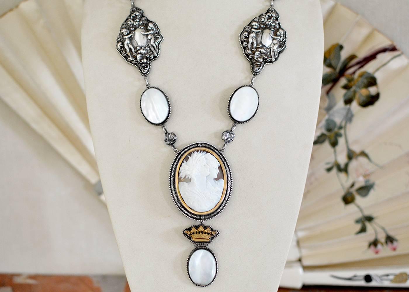 This one of a kind necklace features a fine antique Georgian cameo depicting two Goddesses in 14 karat gold mounted within an elaborately engraved double frame with bronze crown drop connects to a generous mother-of-pearl infused chain. Consisting