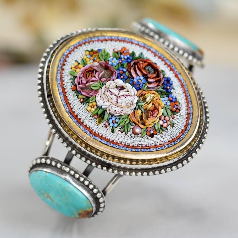 This one of a kind Sterling Silver cuff bracelet features at the center an important large antique nineteenth century Venetian tesserae micro mosaic. Dimensional roses in delightful shades or pink, yellow and white form the raised bouquet. We have