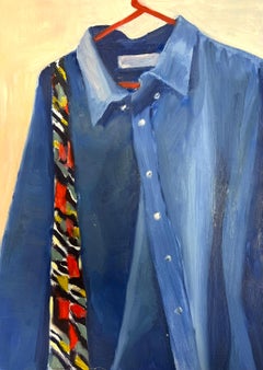 Blue Denim Shirt Hanging on a Red Hanger with a Boldly Patterned Scarf
