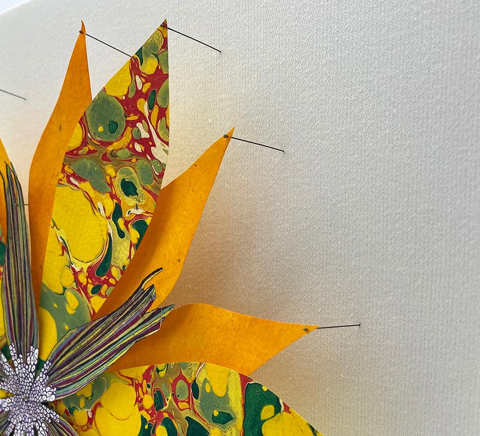 In this bright and colorful paper sculpture, a fantastical botanical form in vibrant golden orange with marbled bright yellow and green is composed of hand-colored etchings on hand-cut handmade Loktah paper, hand-cut marbled paper, and hand-cut,
