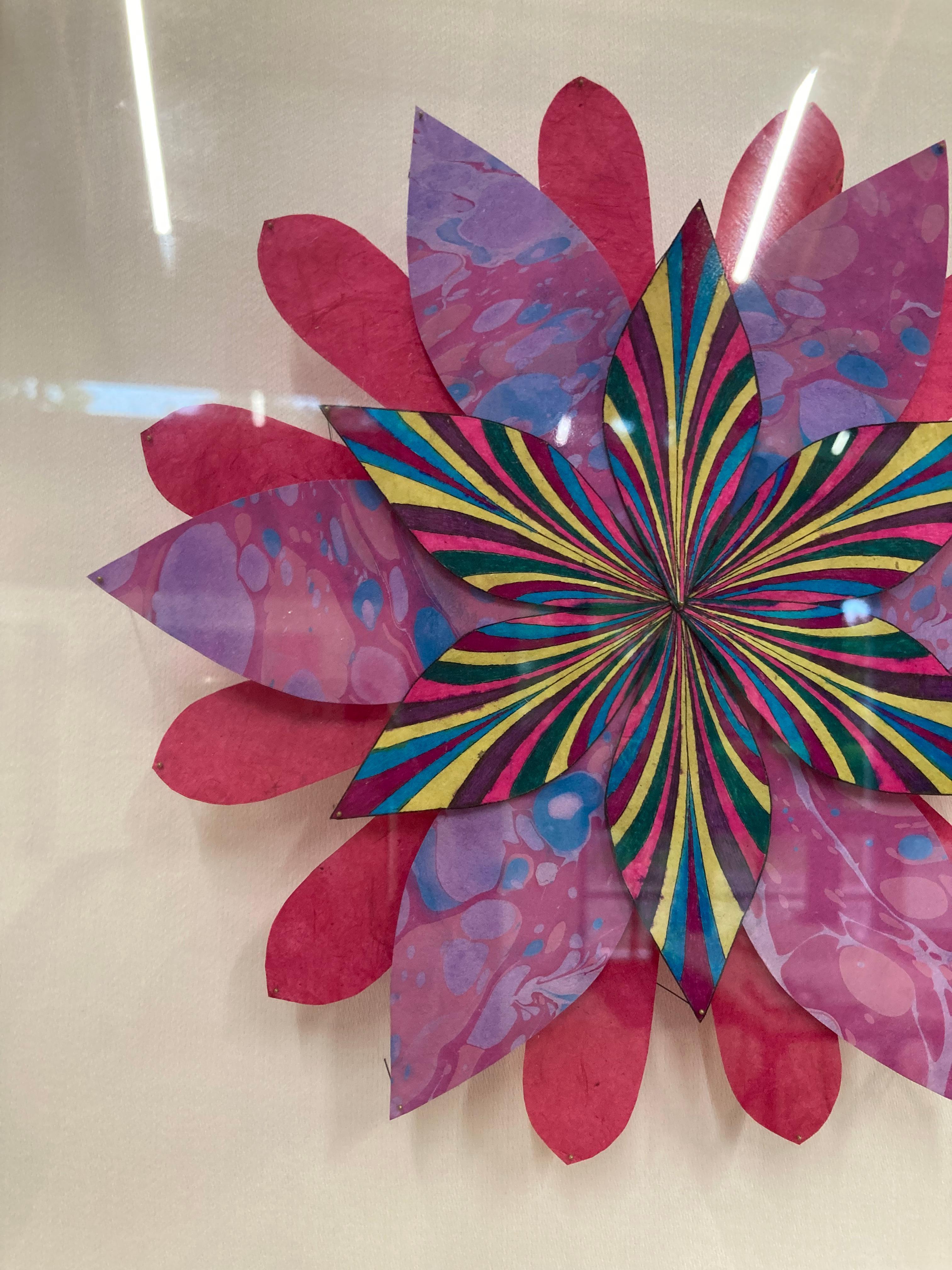 In this bright and colorful paper sculpture, a fantastical botanical form in vibrant magenta purple and marbled pink and blue is composed of hand-colored etchings on hand-cut handmade Loktah paper chine colléd to Rives lightweight paper, hand-cut