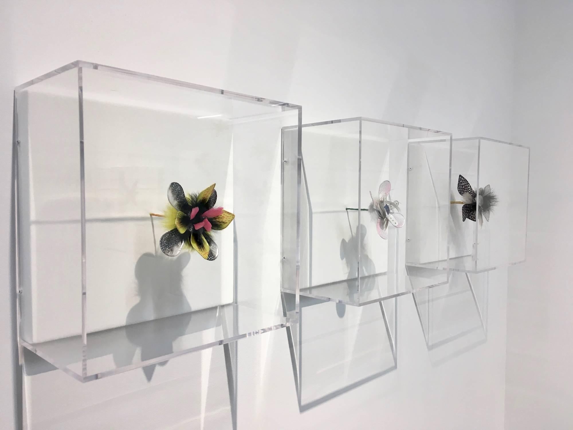 Jill Parisi's masterful sculptures are showcased in this exciting display of a single sculpture of pink, gray, blue, and green acrylic ink on white handmade overbeaten abaca fiber with gray feathers. The papers are hand-cut and arranged in floral
