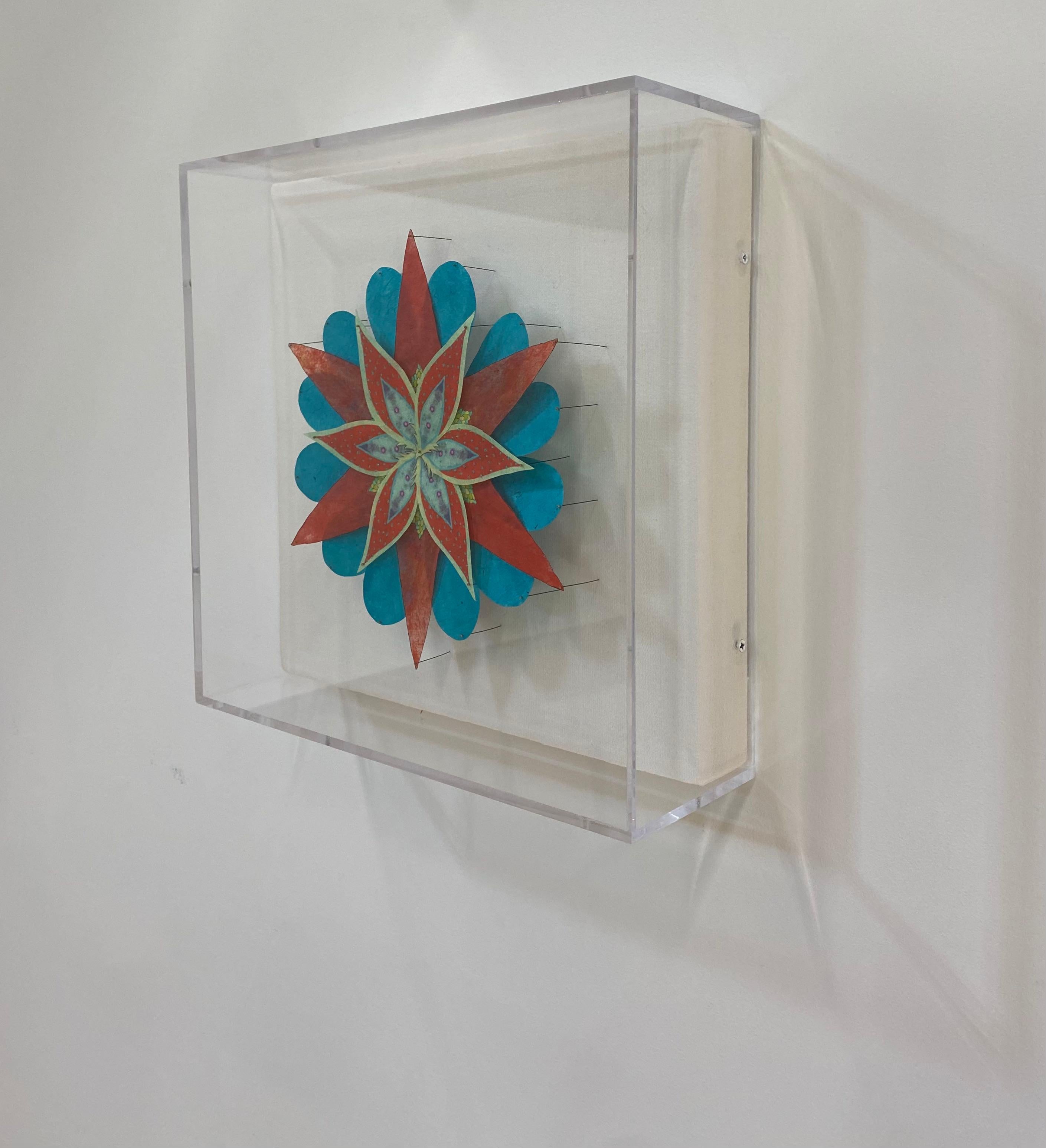 A bright and colorful paper sculpture of a fantastical botanical form in vibrant teal blue, reddish orange and light lime green and yellow. Composed of hand-colored etchings on hand-cut, handmade Loktah paper, hand-colored digital prints on hand-cut