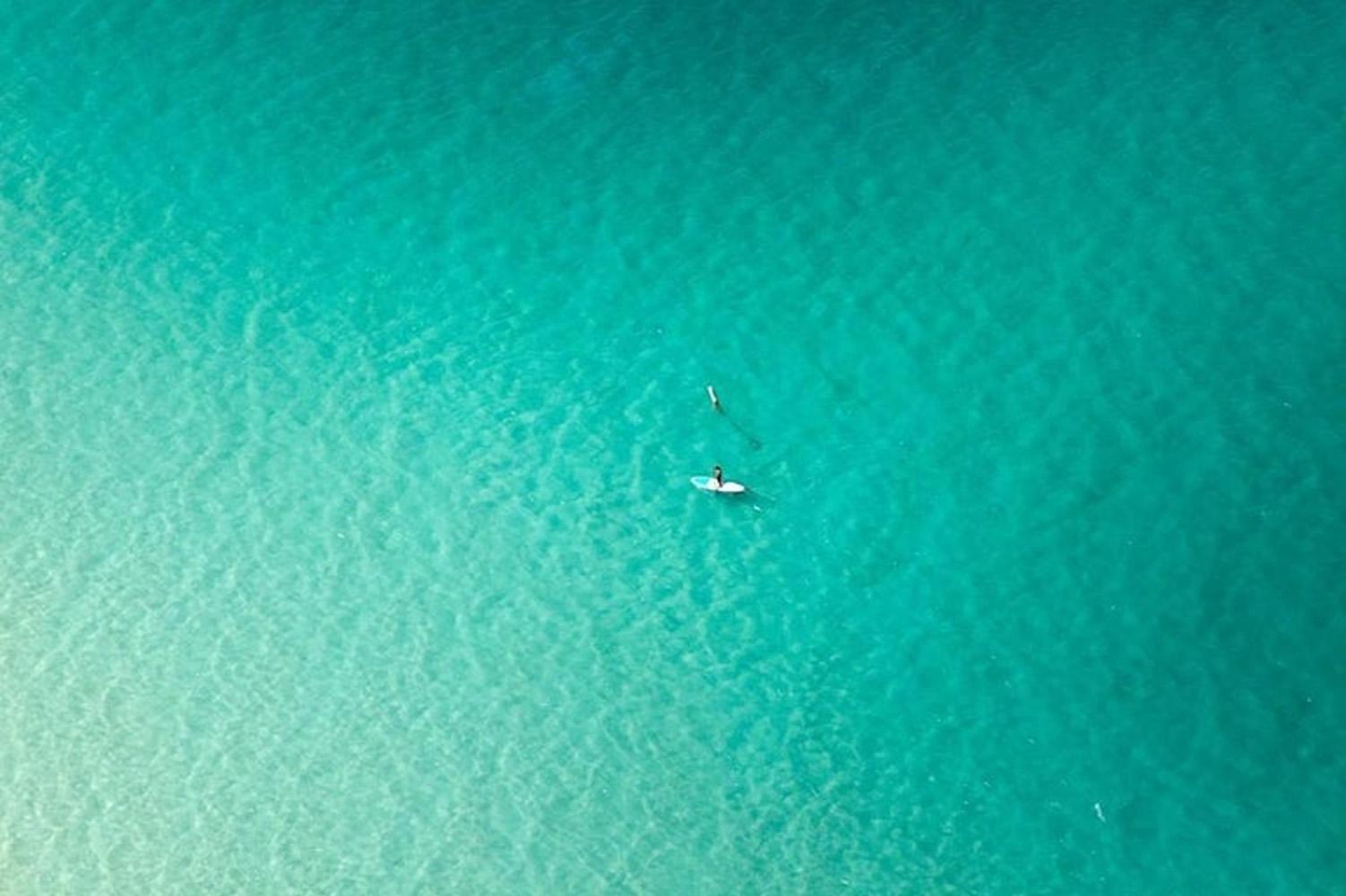 Paddle Boarder e Paddle Boarder solitari. Fotografia a colori del paesaggio oceanico - Photograph di Jill Peters