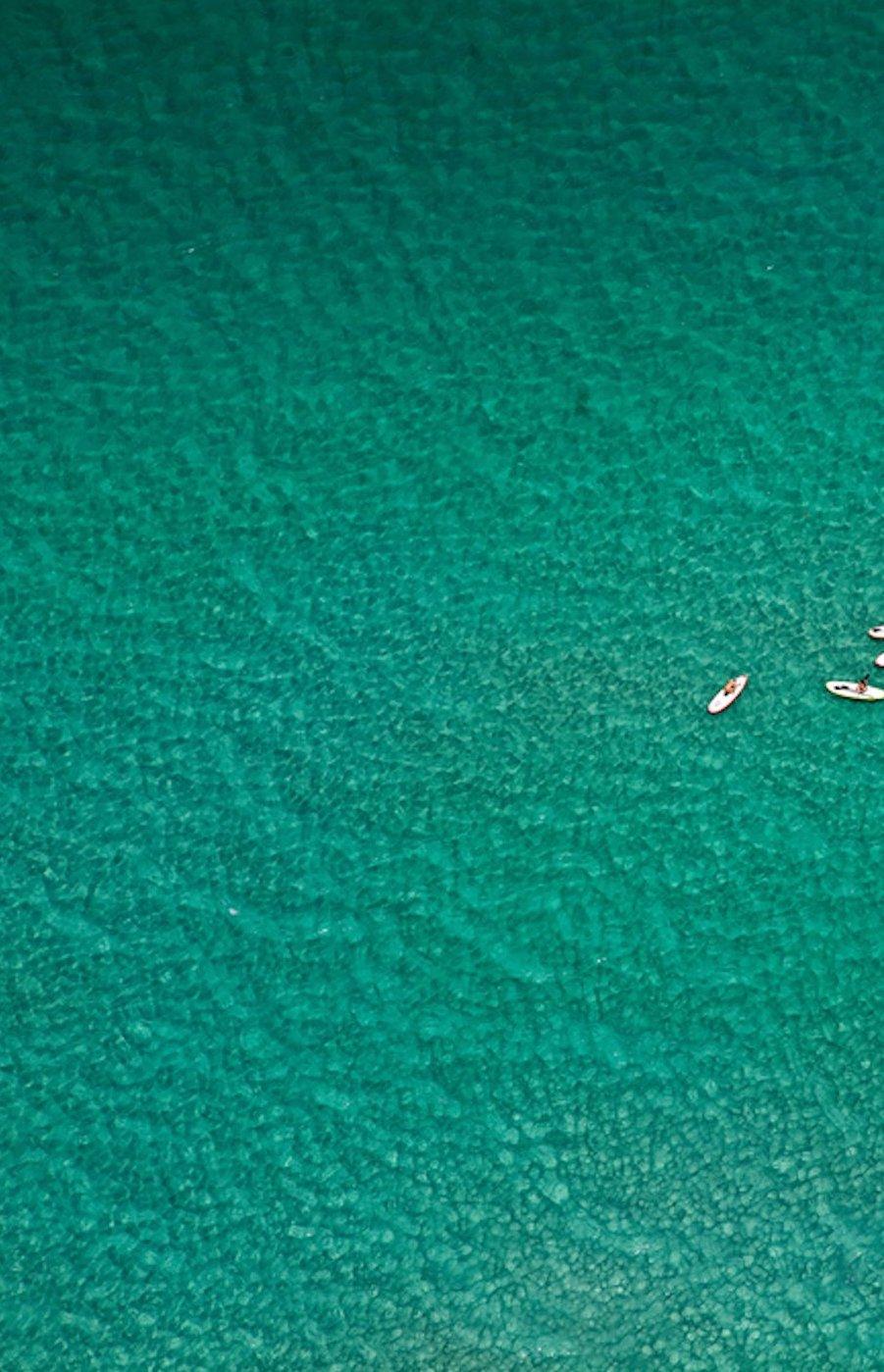 Paddle Boarder e Paddle Boarder solitari. Fotografia a colori del paesaggio oceanico - Landscape Photograph Blu di Jill Peters