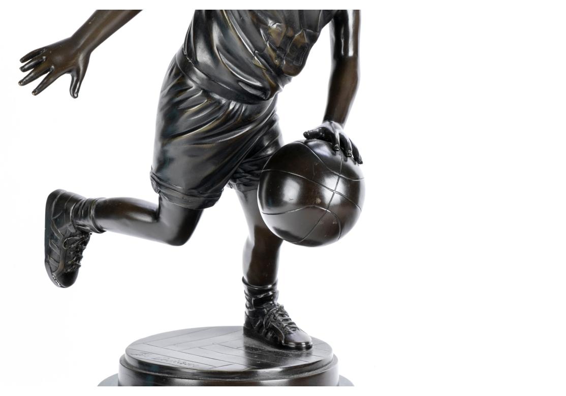 Un ragazzo che palleggia con la palla da basket, su una base rotonda con texture. Montato su una base di marmo nero a più livelli. Firmato sulla base in bronzo. L'artista è noto per i bronzi di giovani sportivi.

Dimensioni: totale figura 24