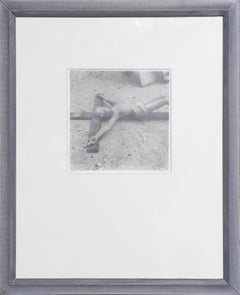 Fotografía en blanco y negro de una escultura de crucifijo encontrada en el suelo