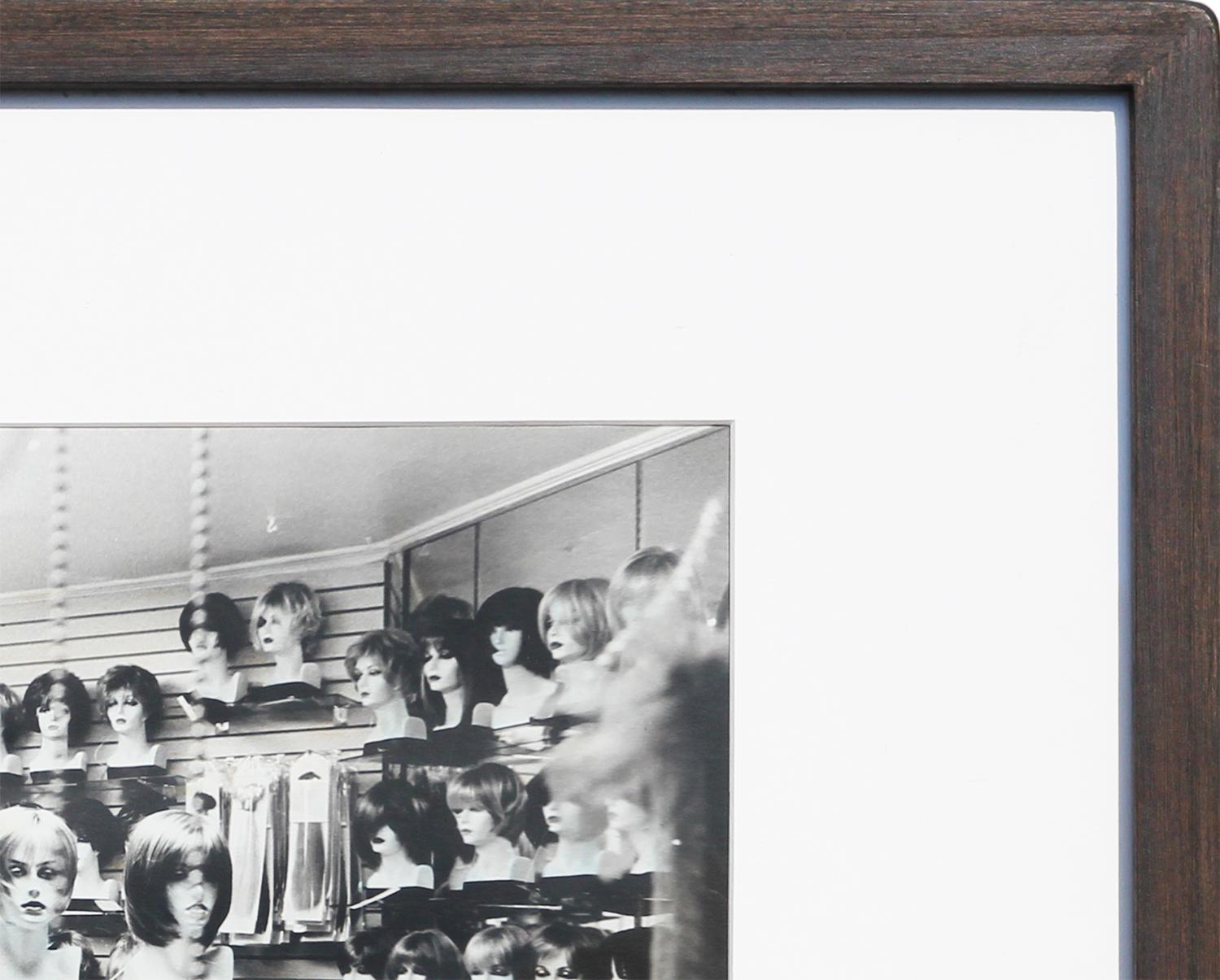 Zeitgenössische Schwarz-Weiß-Fotografie des Künstlers Jim Reitz aus Houston, TX. Dieses Foto zeigt ein Perückengeschäft, das bis zum Rand mit Inventar gefüllt ist. Derzeit in einem schwarzen Rahmen mit breitem, weißem Passepartout