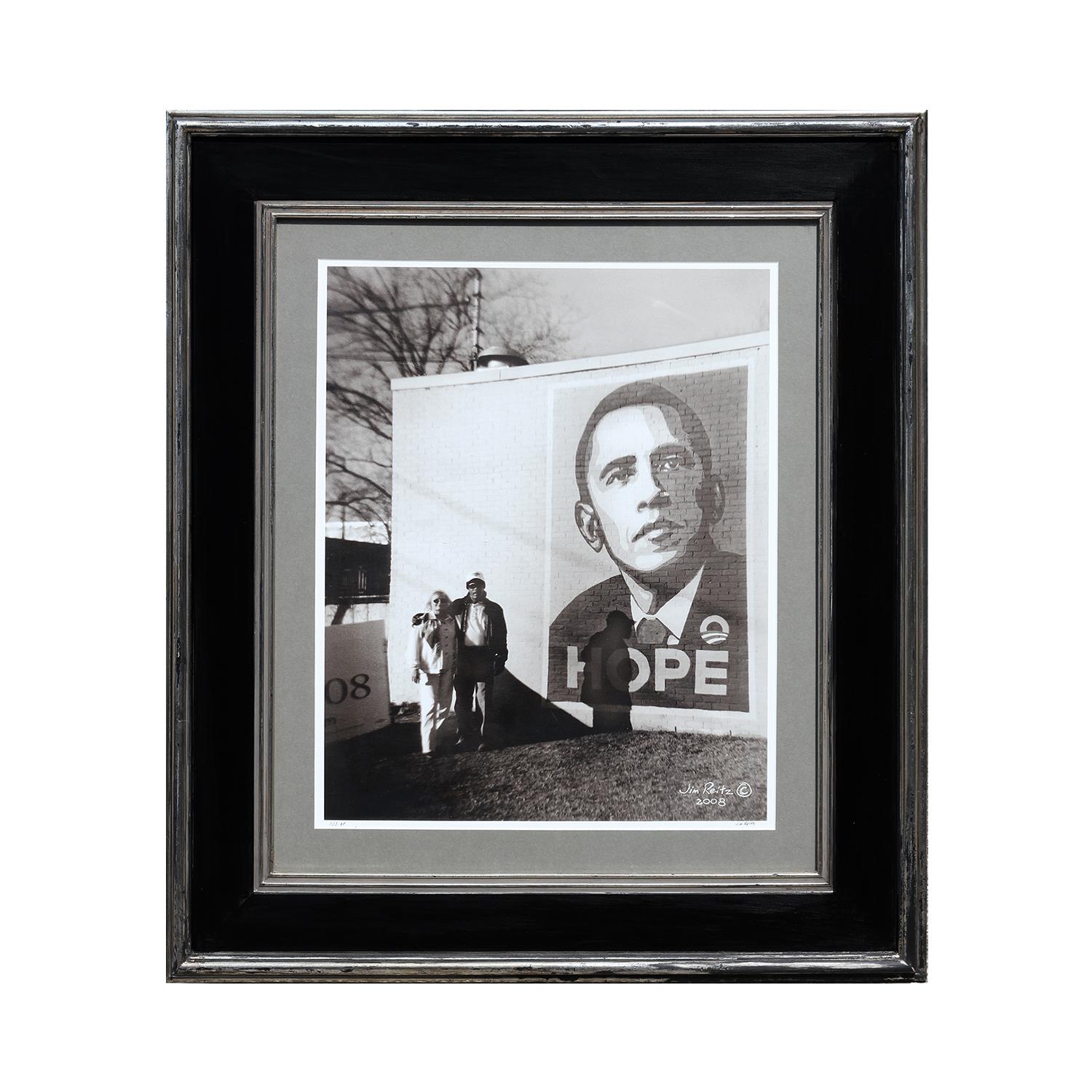 Photographie contemporaine de rue noire et blanche d'un couple avec une fresque murale d' Obama - Noir Black and White Photograph par Jim Reitz