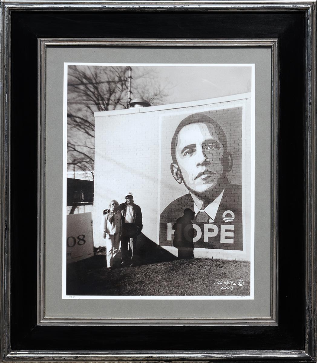 Black and White Photograph Jim Reitz - Photographie contemporaine de rue noire et blanche d'un couple avec une fresque murale d' Obama