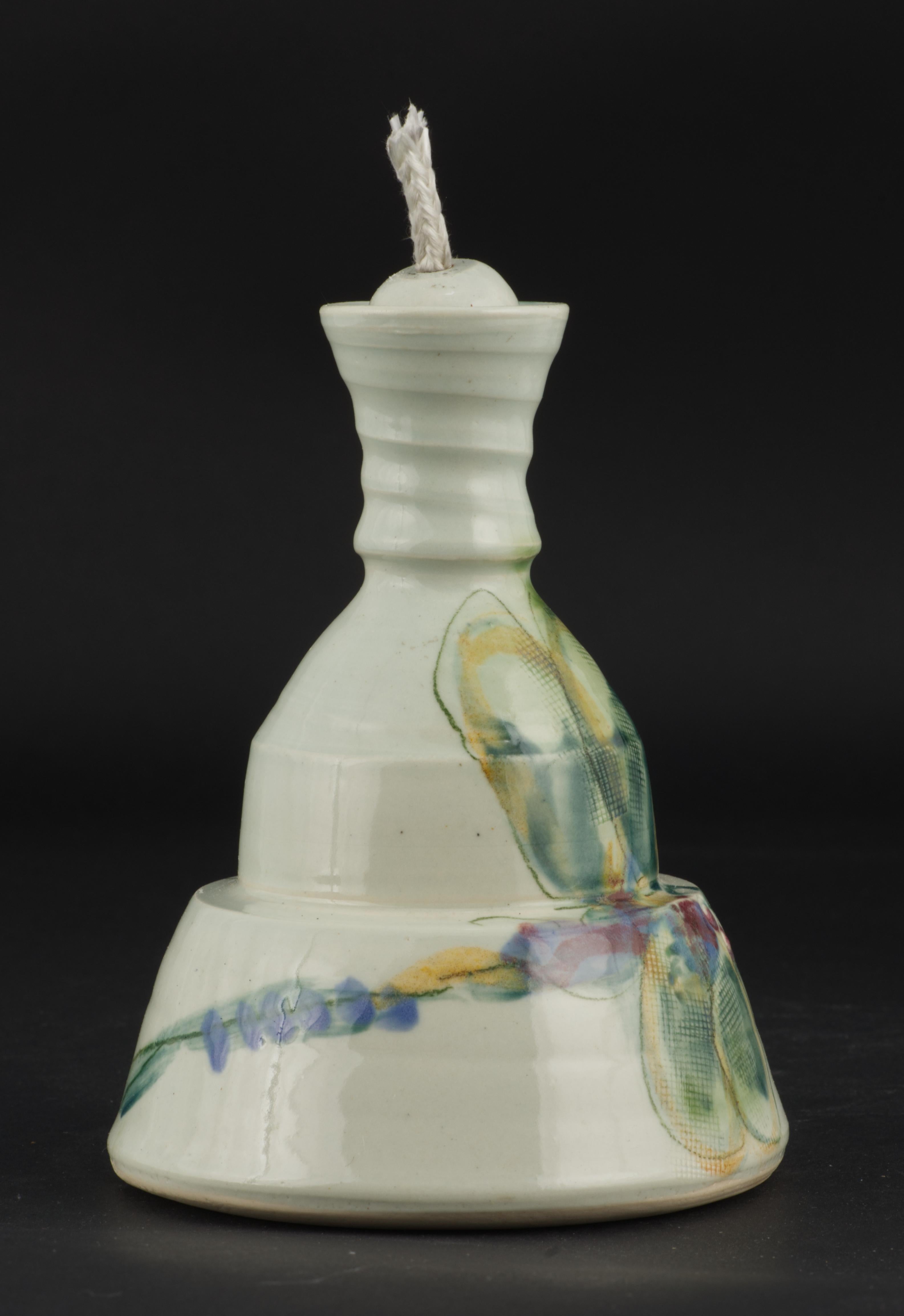 La lampada a olio a forma di libellula dello Studio Pottery A è realizzata a mano da Jim Reno, artista della ceramica che lavora a Mayville, NY. È membro della Chautauqua Crafts Alliance ed è noto per i suoi stravaganti disegni zoomorfi su ceramiche