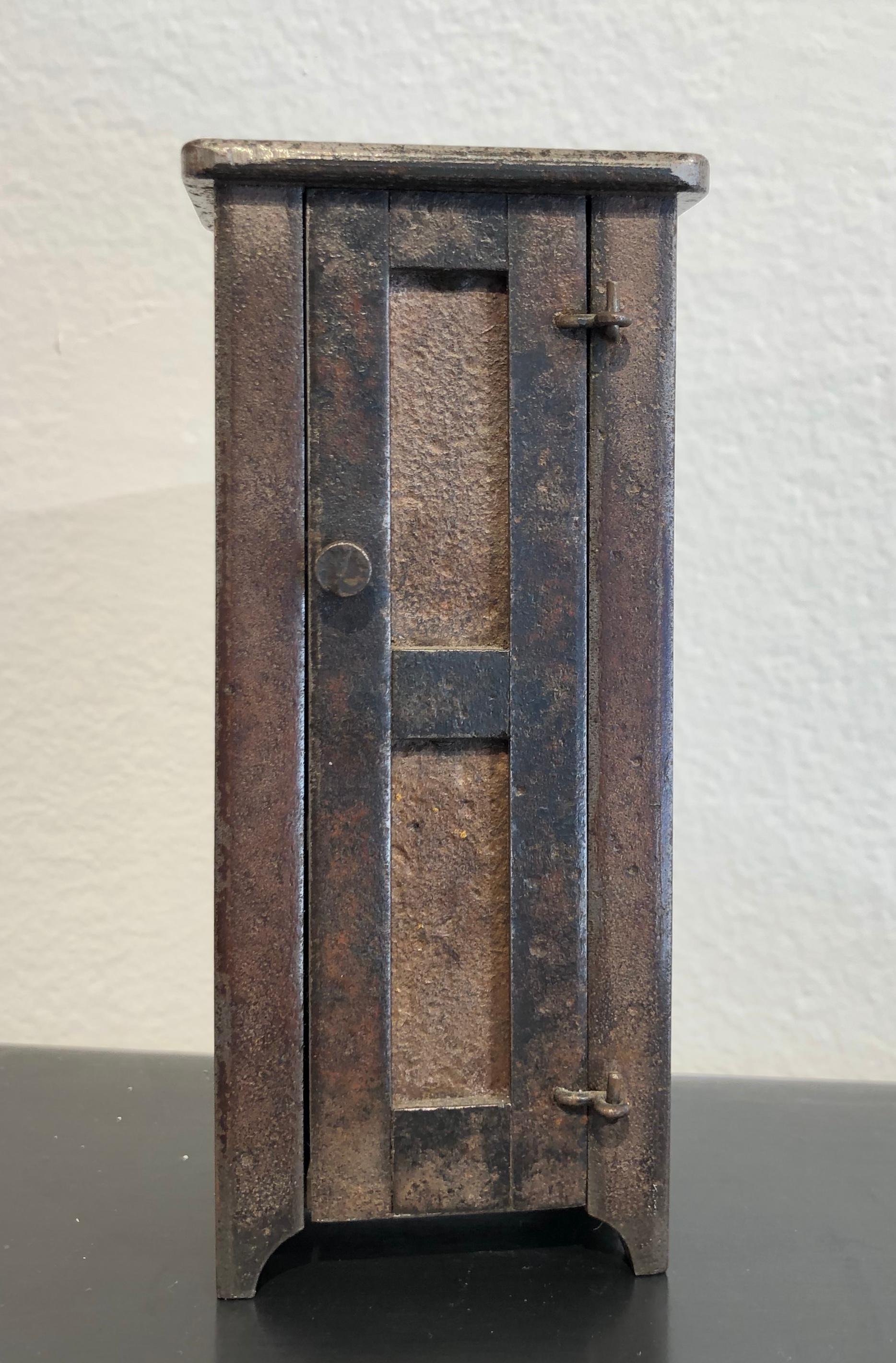 This exquisite miniature chest of drawers is inspired by Shaker furniture. Made from welded steel with a natural rust patina and vintage nail heads for the pull, this tall cabinet is fully functioning with a hinged door and latch. Inside are three