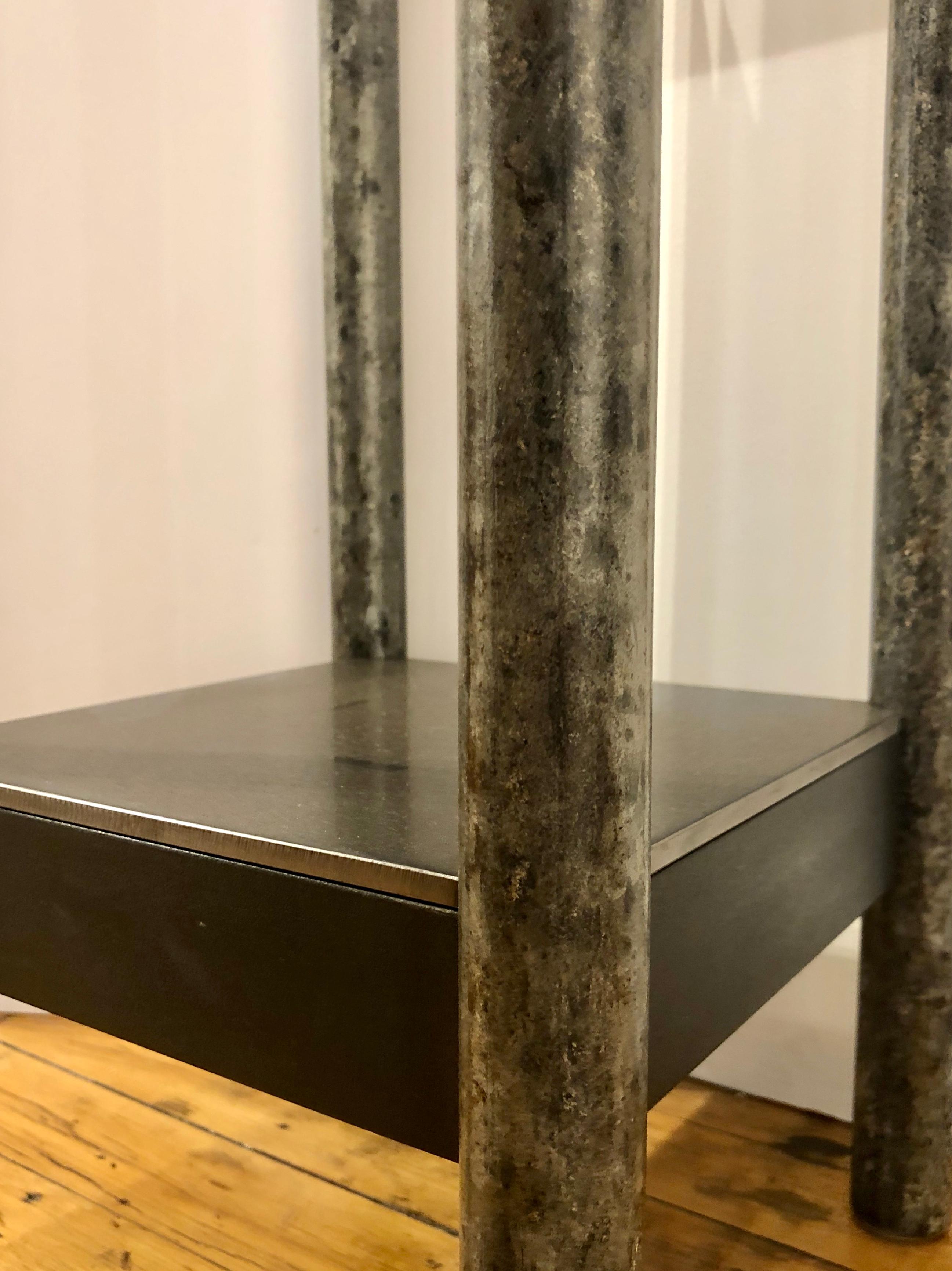 This is a welded steel industrial modern pedestal with a low shelf and skirt. Each piece of furniture is unique and made by Jim Rose. The legs are salvaged galvanized steel pipe. This table represents the ultimate in sustainable design and is