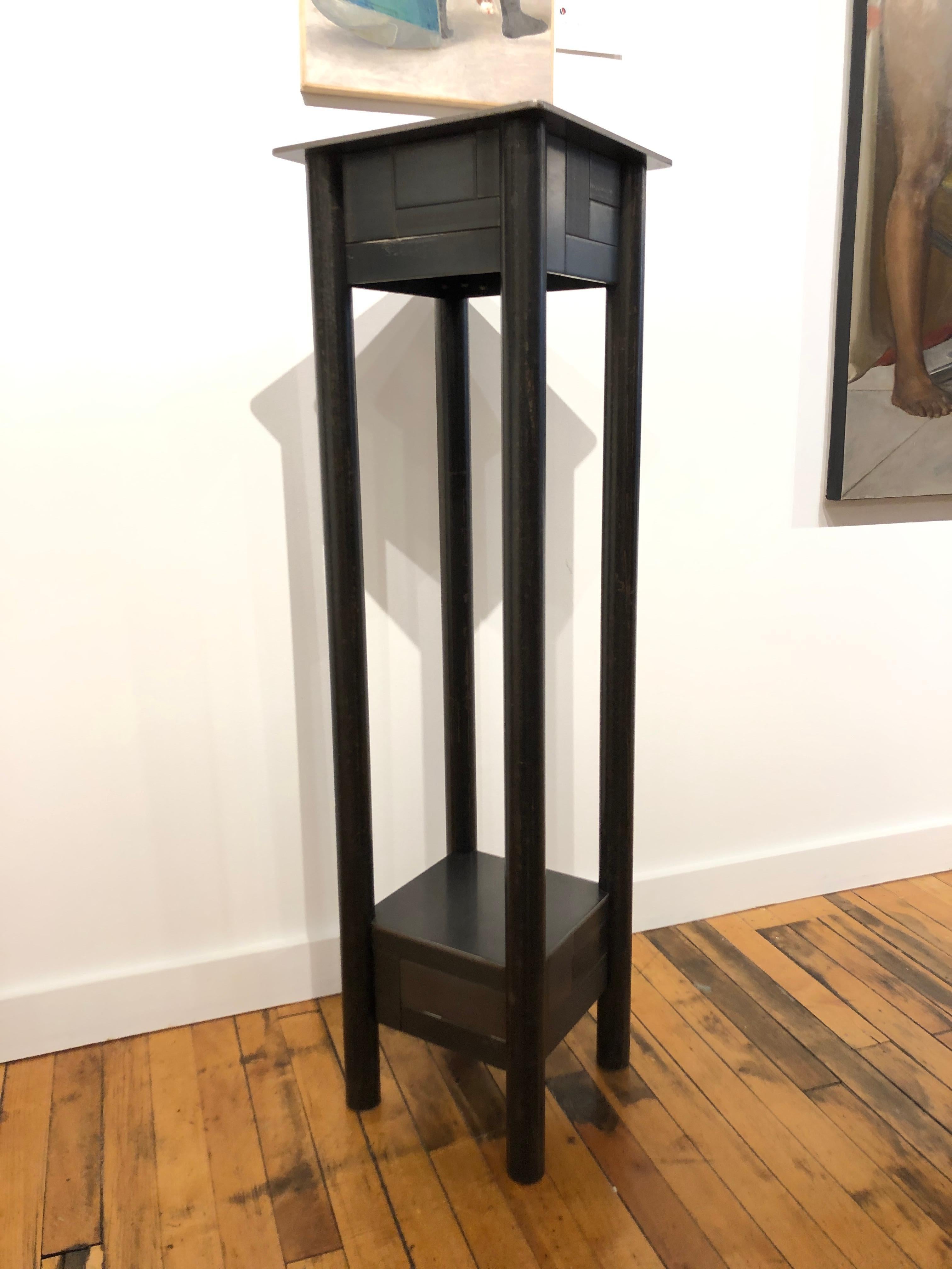 This is a welded steel industrial modern pedestal with a low shelf and a monochromatic skirt of steel panels arranged in a quilt pattern inspired by the quilts of Gee's Bend Alabama. Each piece of furniture is unique and made by Jim Rose. The skirt