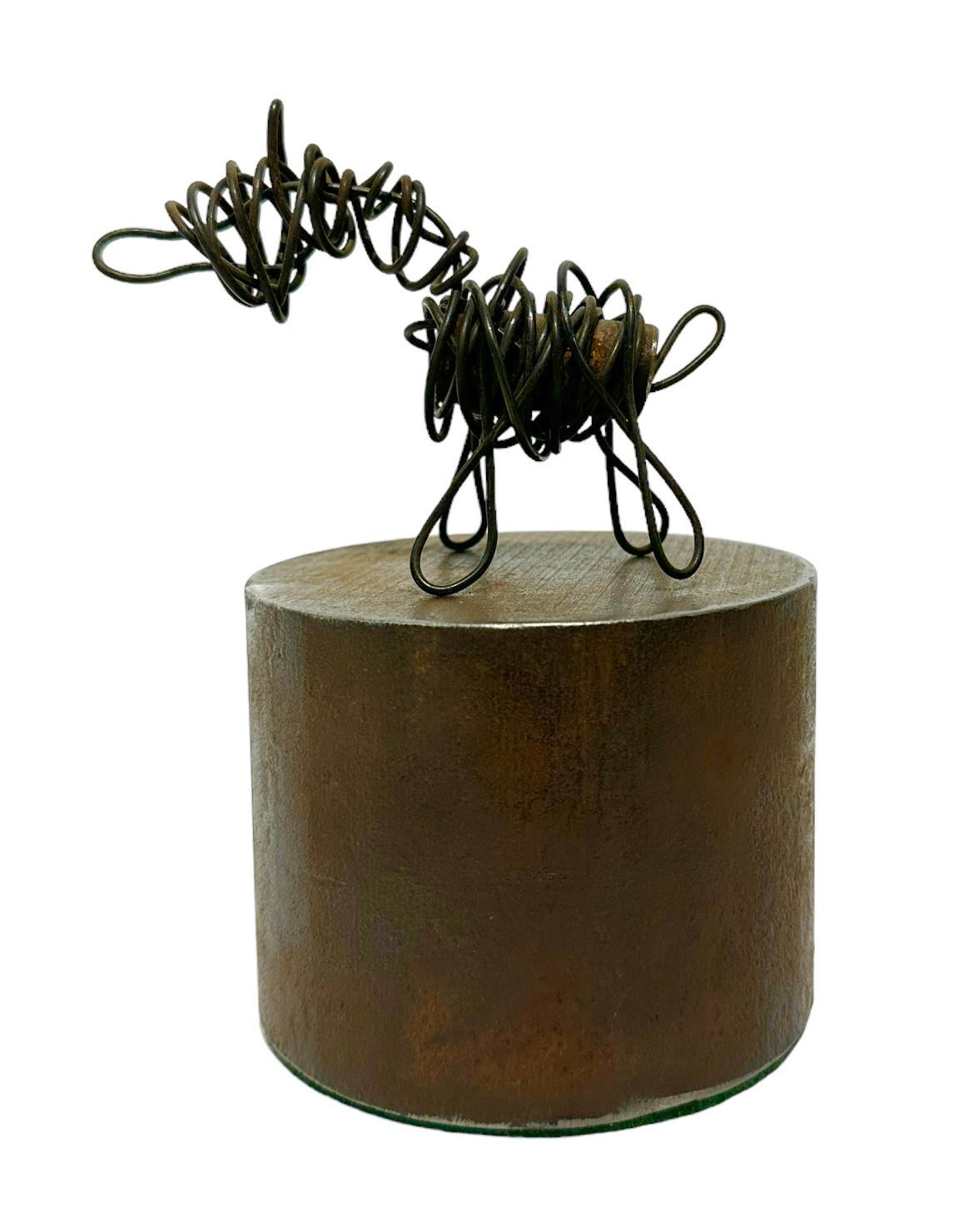 Jim Rose, known primarily for his steel furniture, was an avid collector and scoured salvage yards for unique, interesting items.  Here he has taken heavy gauge wire and formed it into a simple dog and placed it upon a salvaged steel cylinder. 