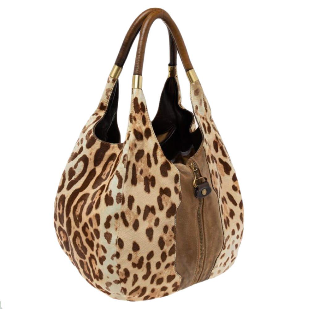 This Mandah Expandable hobo from the House of Jimmy Choo is simply matchless in its luxurious and latest design. It is made from beige-brown leopard-printed calf hair and suede. It features a single handle, gold-toned hardware, and a spacious