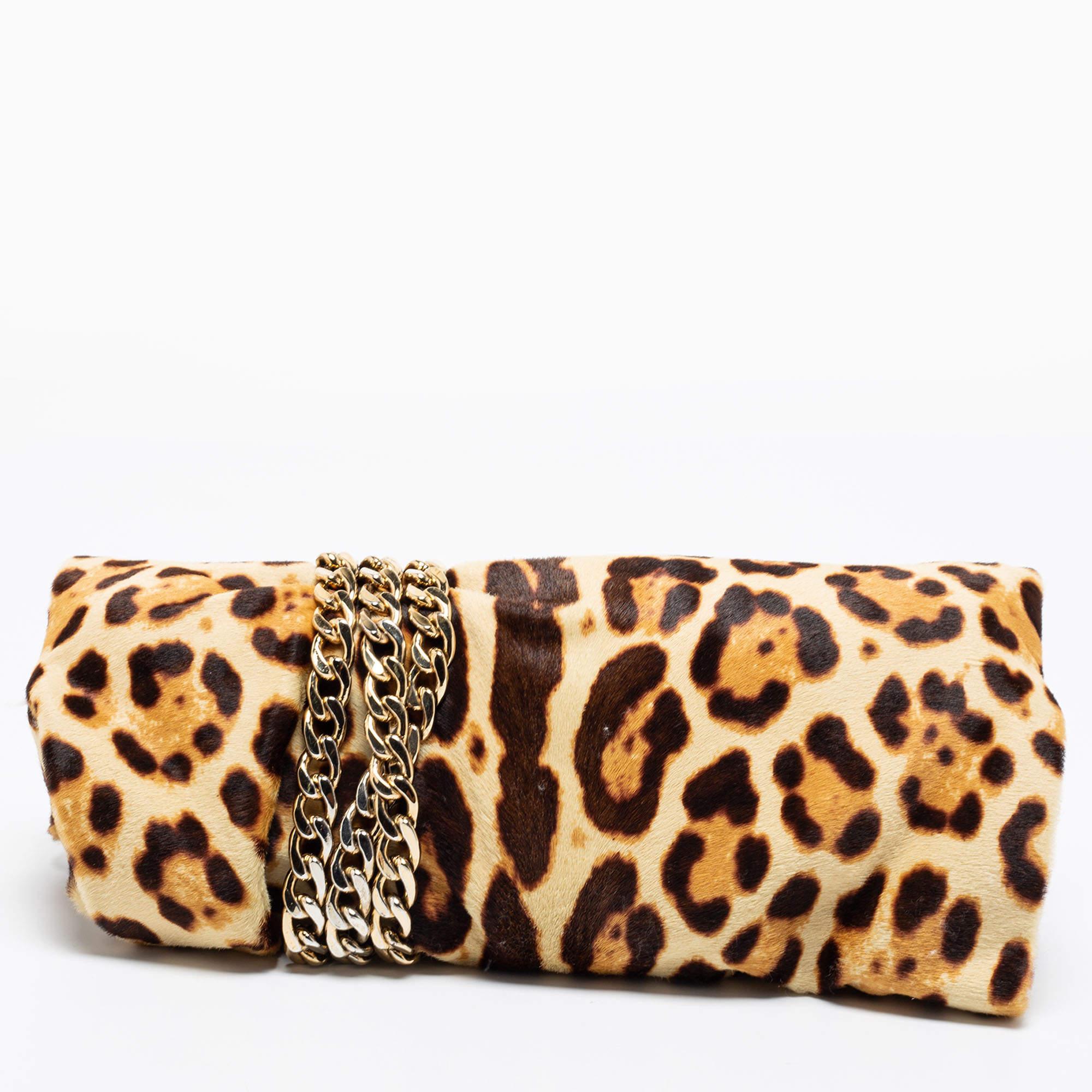 Accessorize this Jimmy Choo clutch with your outfit for your next evening party. Exquisitely crafted from leopard-printed calf hair, its silhouette is enhanced with a gold-tone chain link wound around it to end with a padlock. The Alcantara-lined