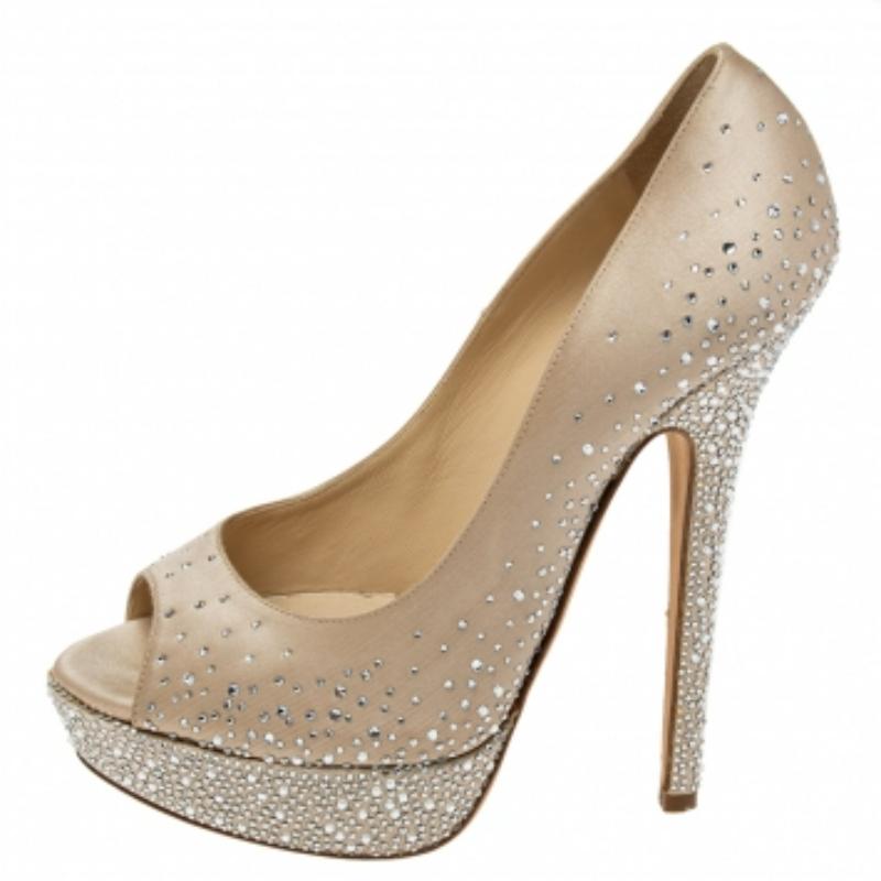 Zeitlos, schick und glamourös - ein Paar Pumps von Jimmy Choo peppt Ihren Look im Handumdrehen auf! Dieses hübsche beigefarbene Paar wurde aus Satin in einer Peep-Toe-Silhouette mit atemberaubenden Kristallverzierungen gefertigt und steht auf