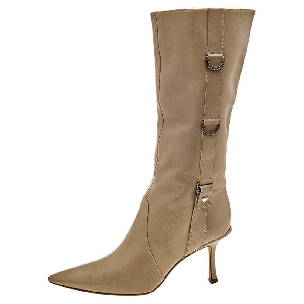 Let your luxe styling choices be evident as you wear these boots from the House of Jimmy Choo. They are made from beige leather and feature silver-toned accents on their structure. They comprise of pointed toes, a calf-length style, and slender