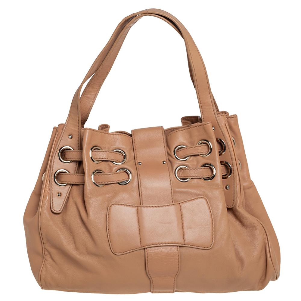 The popular Ramona is another perfectly designed, practical handbag from Jimmy Choo. Crafted from beige leather, it is accented with double straps, a flip-lock closure, and dual shoulder handles. The interior is lined with Alcantara and features a
