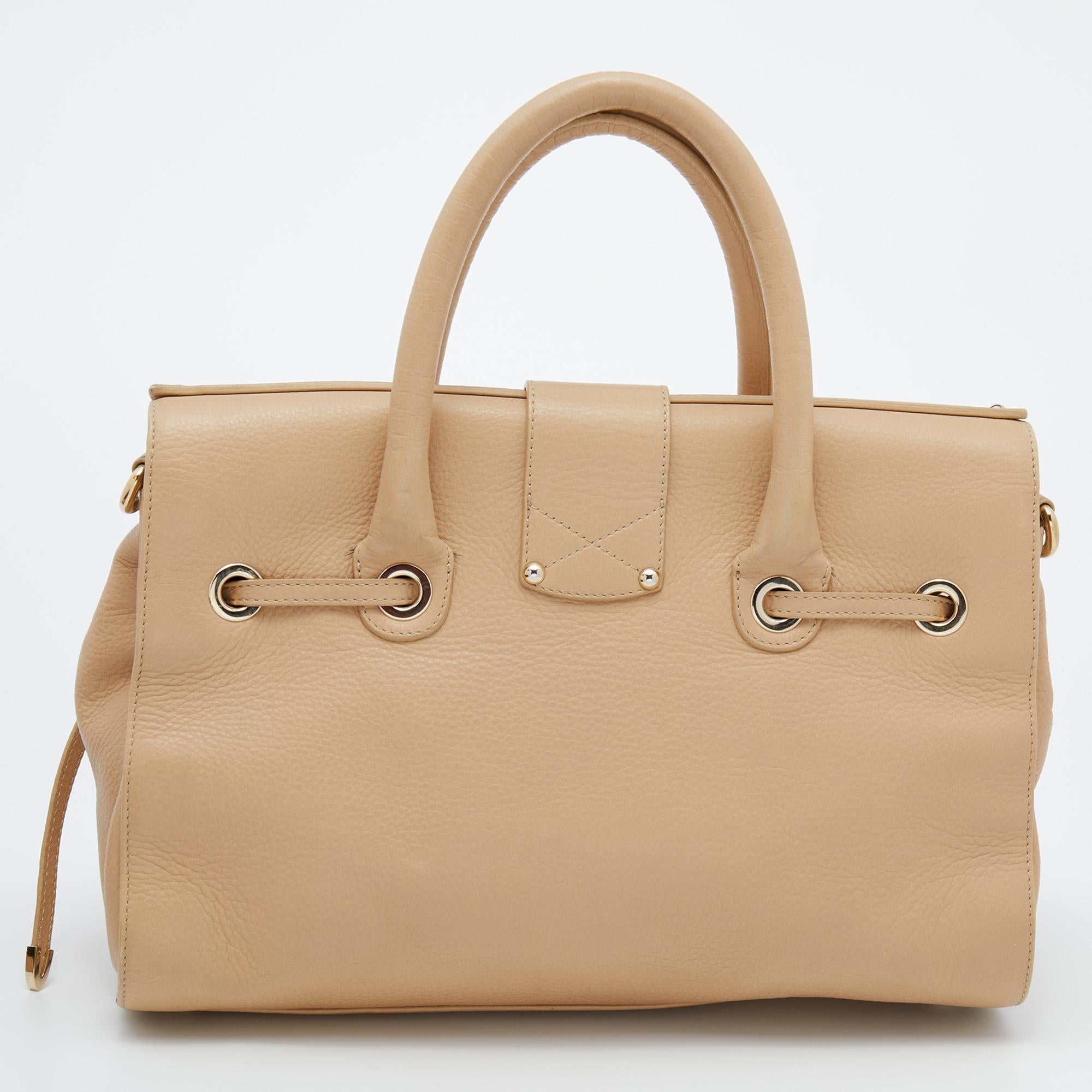 This Jimmy Choo Rosalie satchel is a practical handbag with an elegant touch. Crafted from leather, it is accented with a logo-engraved closure in gold tone. It features a drawstring-like design, double handles, a removable shoulder strap, and