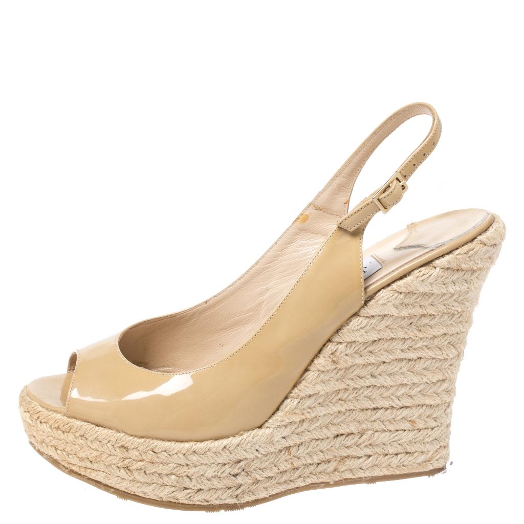 Look elegant and stylish in this beautiful pair of Jimmy Choo wedge sandals that are perfect to wear through the day and even for your casual evenings out. Constructed in beige patent leather, these sandals feature slingbacks and espadrille wedge