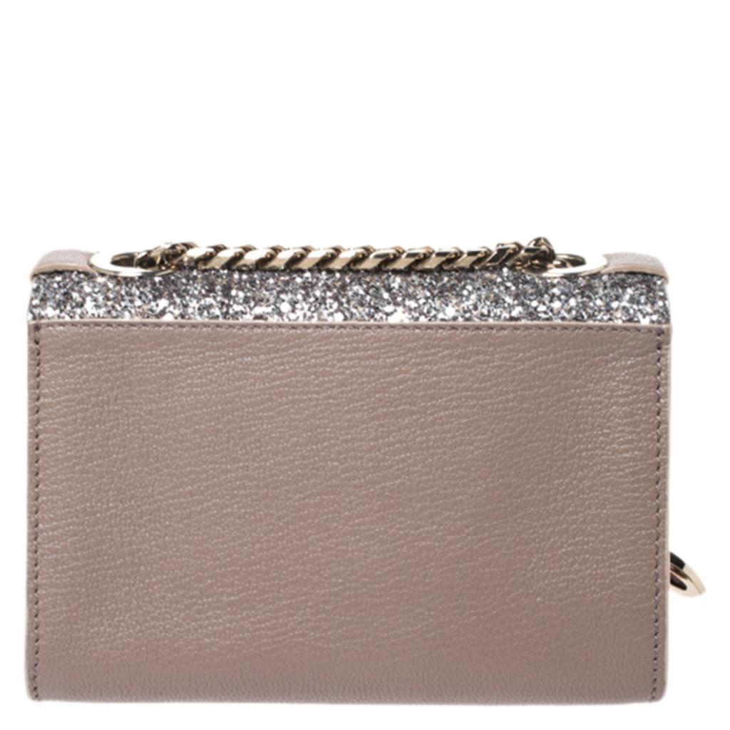 This stunning Rebel crossbody bag from Jimmy Choo is high on appeal and style. The bag is crafted from leather as well as glitter and designed with a flap that has a flip lock leading way to a leather interior. The bag is held by an adjustable