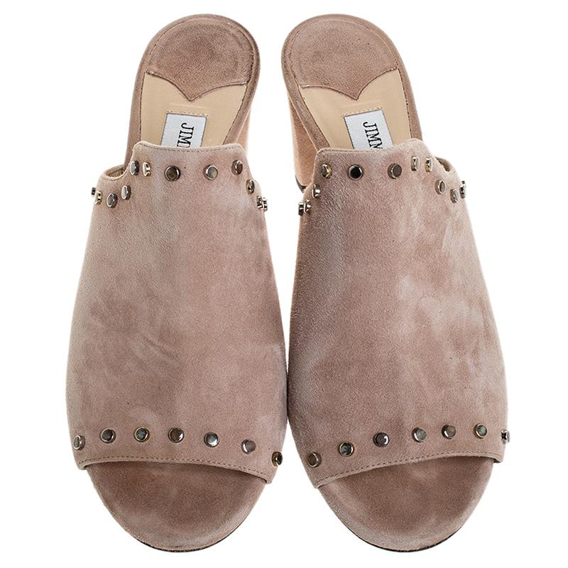 Fashion and poise will all come naturally to you when you step out in this pair of beige mules from Jimmy Choo. Crafted from suede, the mules have been styled with leather insoles, open toes, 6.5 cm heels and detailing of studs.

Includes: Original