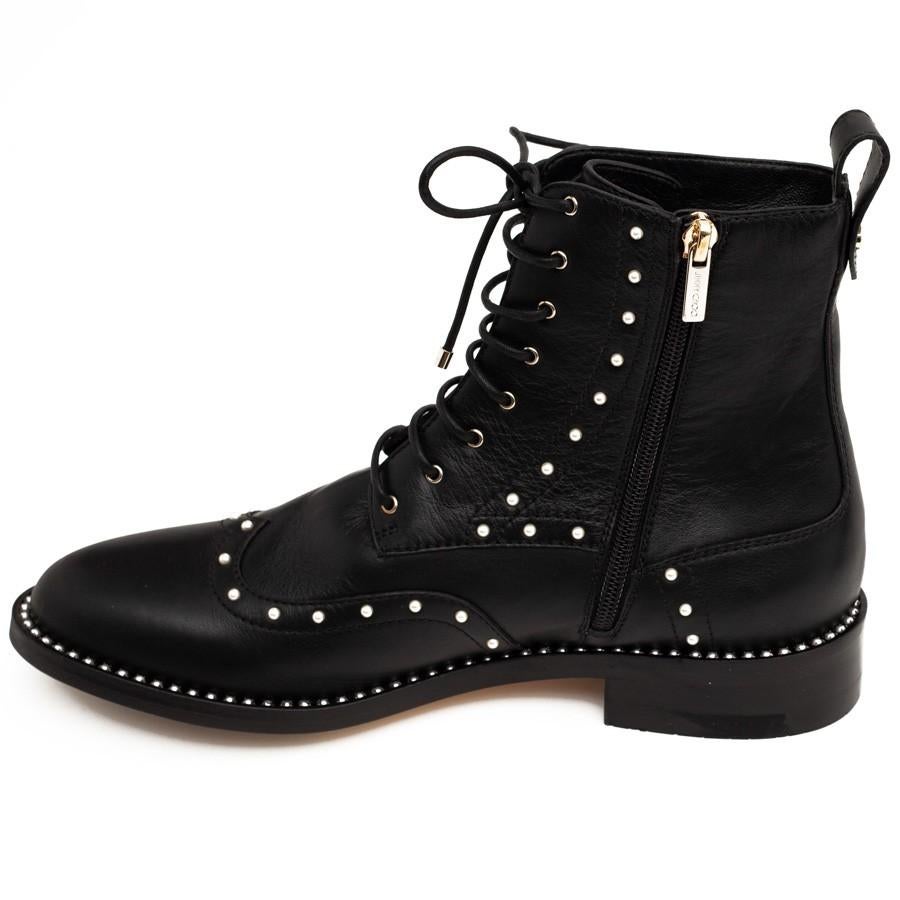 New, never worn and still in the box with dust bag. Lovely pair of Jimmy Choo lace up boots, made of black leather and adorned with small pearls that soften the rock style. Lace up put easy to put on thanks to the gold toned zipper, and comfortable