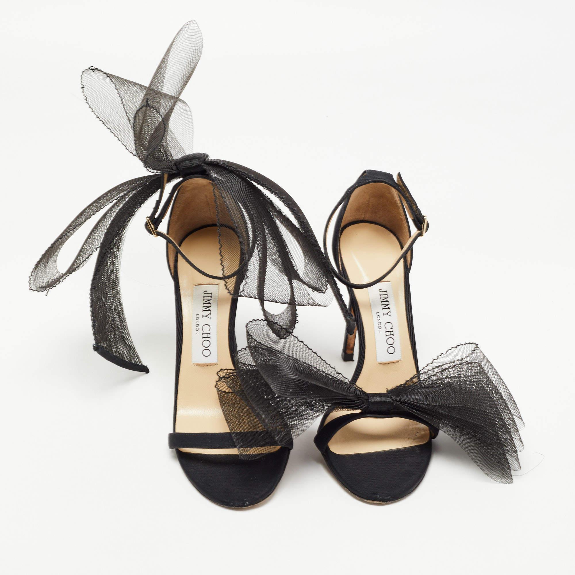 Festooned with mesh bows and mounted on slim heels, these Aveline sandals from Jimmy Choo will add a chic-feminine touch to your look. They are created using black canvas & leather and exhibit open toes, gold-tone hardware, and an ankle