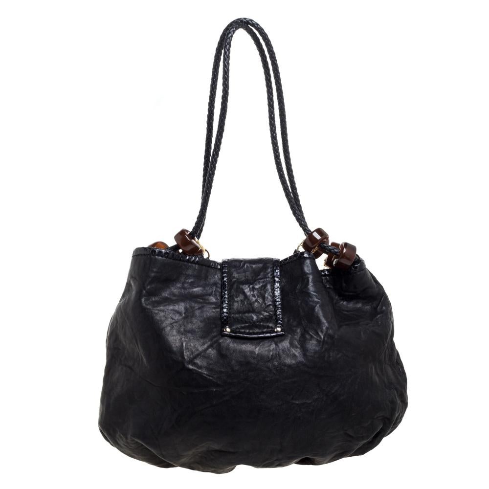 Grace your love for bohemian designs with this stylish and chic Jimmy Choo Roxana hobo. Constructed in black crinkled leather, this bag features two braided long handles with brown beads and fringe detail. With a gold-tone strap buckle closure at
