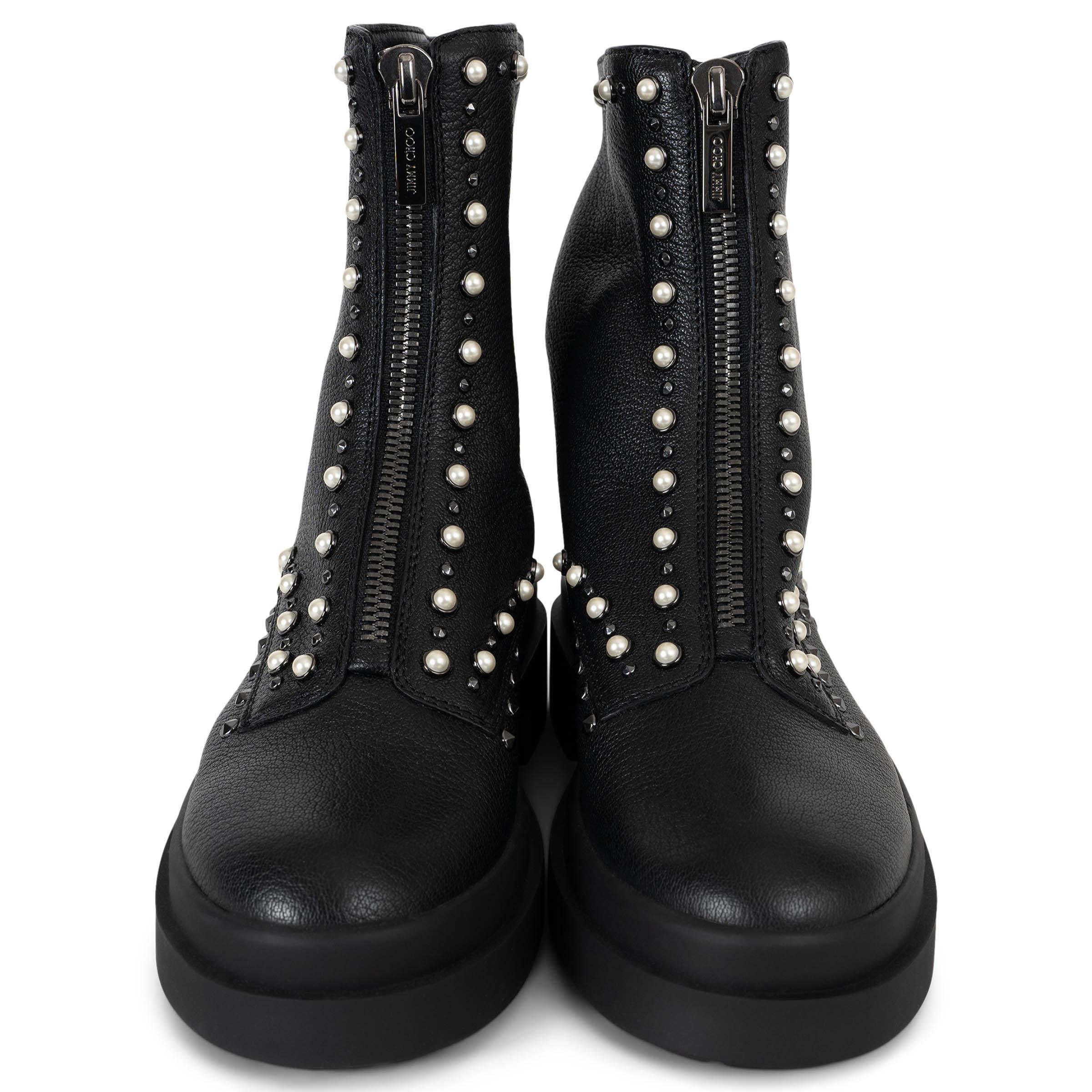 This 100% authentic Jimmy Choo Nola combat boots in black grainy leather redefine edgy elegance. Trimmed with alternating pearl cabochons and silver-tone studs, they feature rounded toes, thick rubber soles, and sturdy block heels for a bold yet