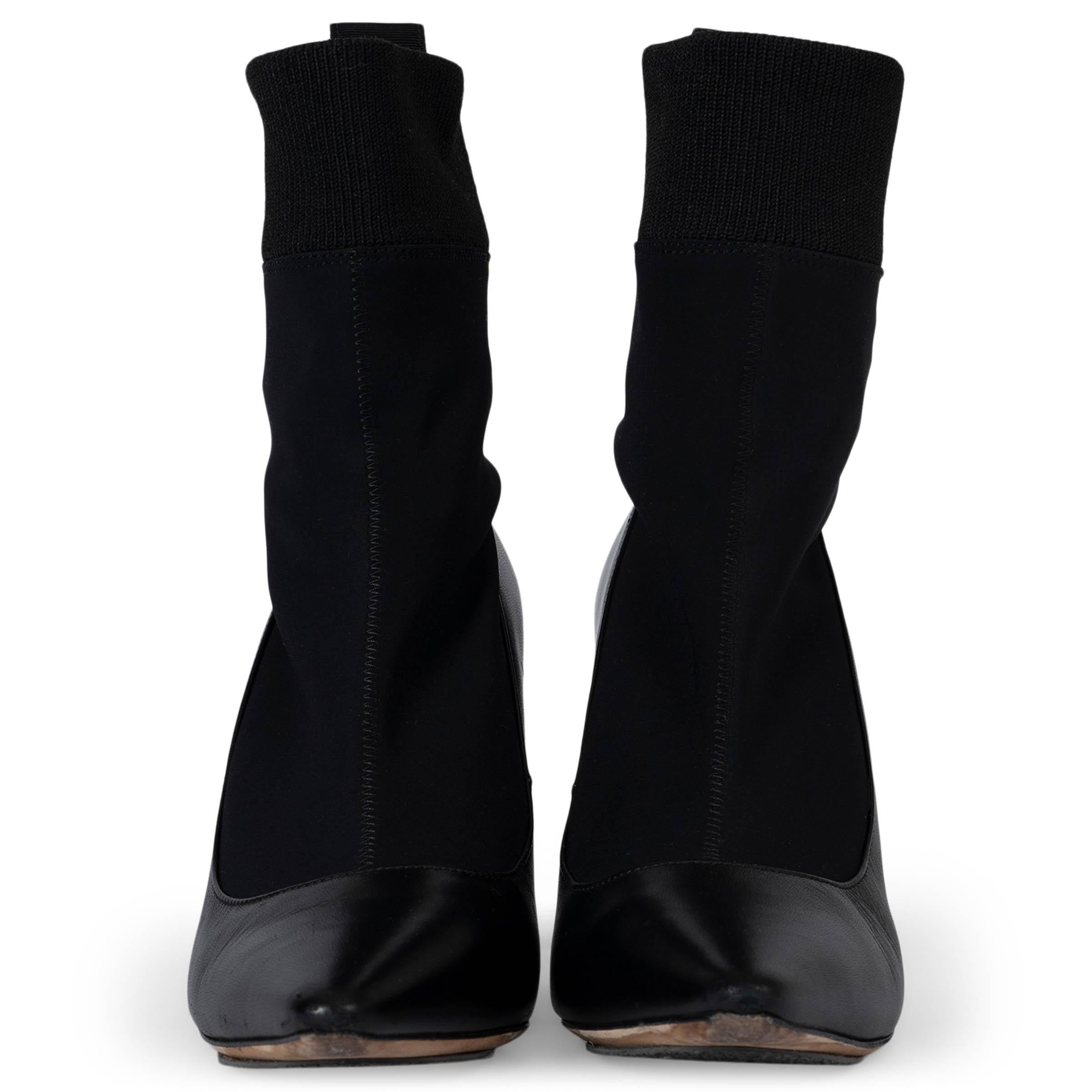 These 100% authentic Jimmy Choo Brandon 100 Ankle Sock Boots are crafted from black nappa leather and neoprene stretch fabric. They feature a sleek pointed-toe design and stretch rib fabric around the ankle for a snug, modern fit. The signature 'I