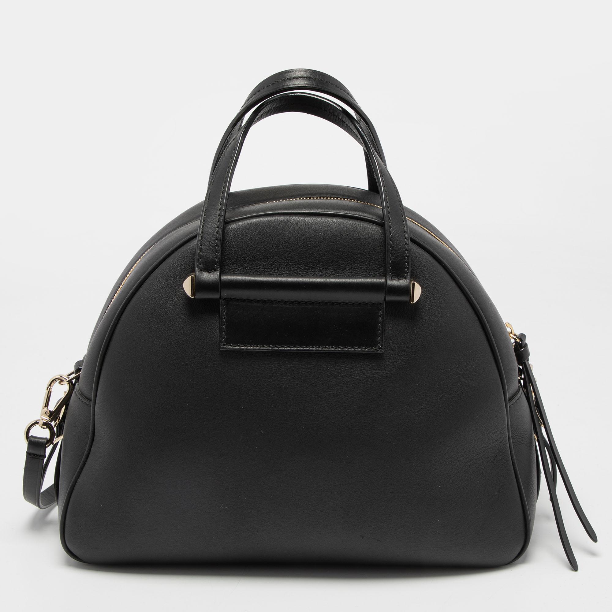Luxuriously crafted, this Jimmy Choo Varenne Bowler bag is splendid to look at and flaunt this season. It has been crafted from black leather and features dual handles, gold-tone 'JC' logo and buckle strap details on the front, and a top zip