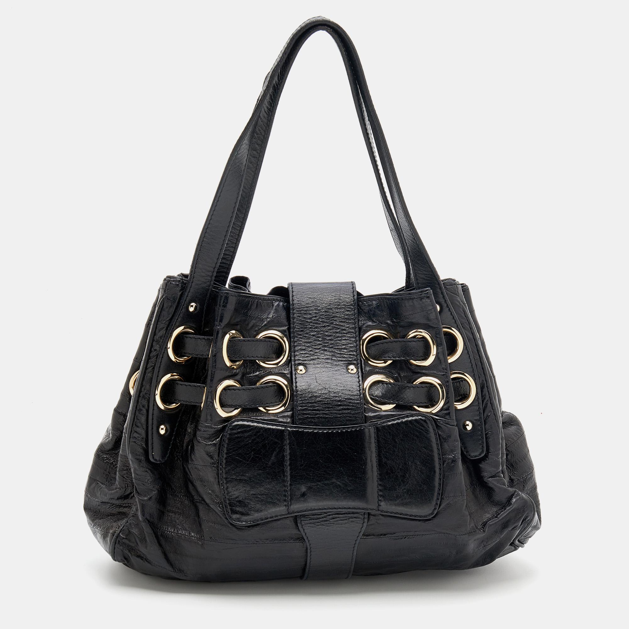 This Jimmy Choo Riki tote is a result of exquisite details and faultless craftsmanship. Created from leather, this bag rules the wishlist of style enthusiasts worldwide. It is made striking with two straps passing through the gold-tone eyelets, and