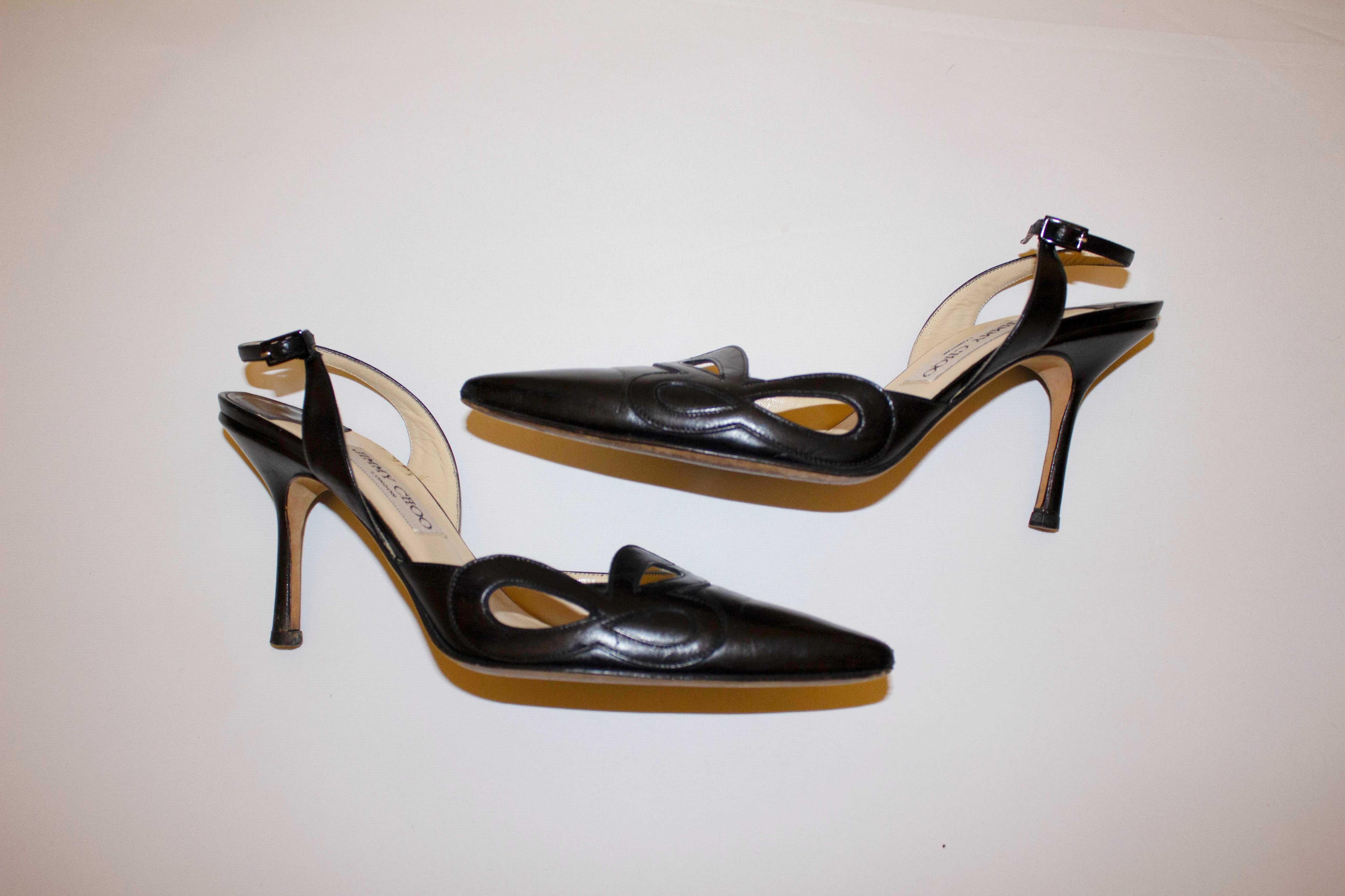 A stylish pair of sling back heels from Jimmy Choo. In black leather with cut out detail on the outer side, the heels measure nearly 4'' in height, shoe size 40. Excellent condition.
