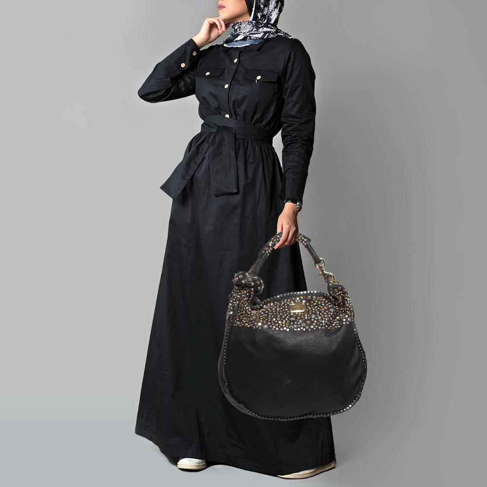 This stunning hobo from Jimmy Choo is crafted in Italy and is sure to make a standout addition to your collection. The studded Sky bangle hobo is crafted from black leather and comes with two-tone hardware and a flat top handle. The bag is finished