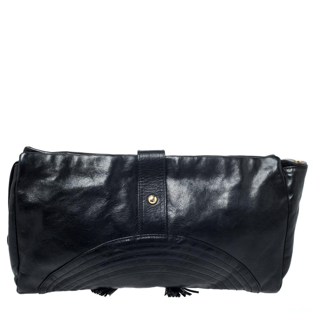 This lovely clutch from Jimmy Choo is a must-have. It has been crafted in Italy and is made of black leather. It has been designed to deliver style and functionality. It has a strap closure with gold-tone hardware and a tassel. The clutch opens to a