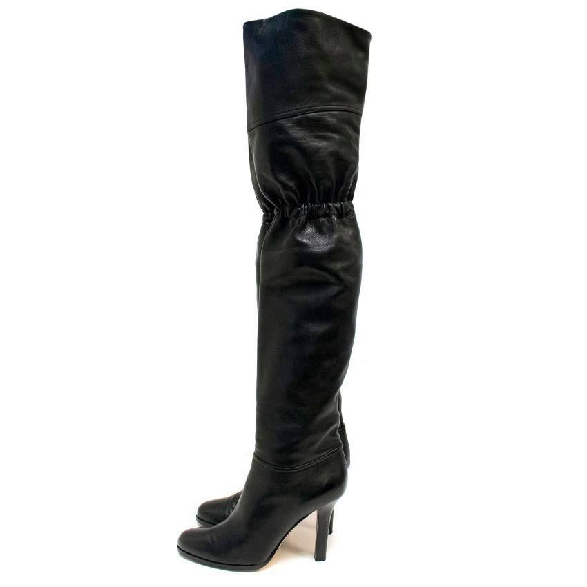 Jimmy Choo black over the knee heeled boots. These boots feature a cinched knee with round silver hardware on the back side of the cinching. 

Condition: 9/10 Soles show slight wear. 

Approx measurements: 
Width: 10cm 
Length: 68cm 
Heel Height: