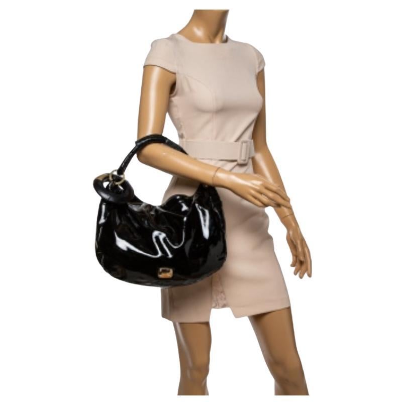 This stunning hobo from Jimmy Choo is crafted in Italy and is sure to make a standout addition to your collection. The Sky hobo is crafted from patent leather as well as snakeskin and comes with gold-tone hardware and a top handle. The bag is