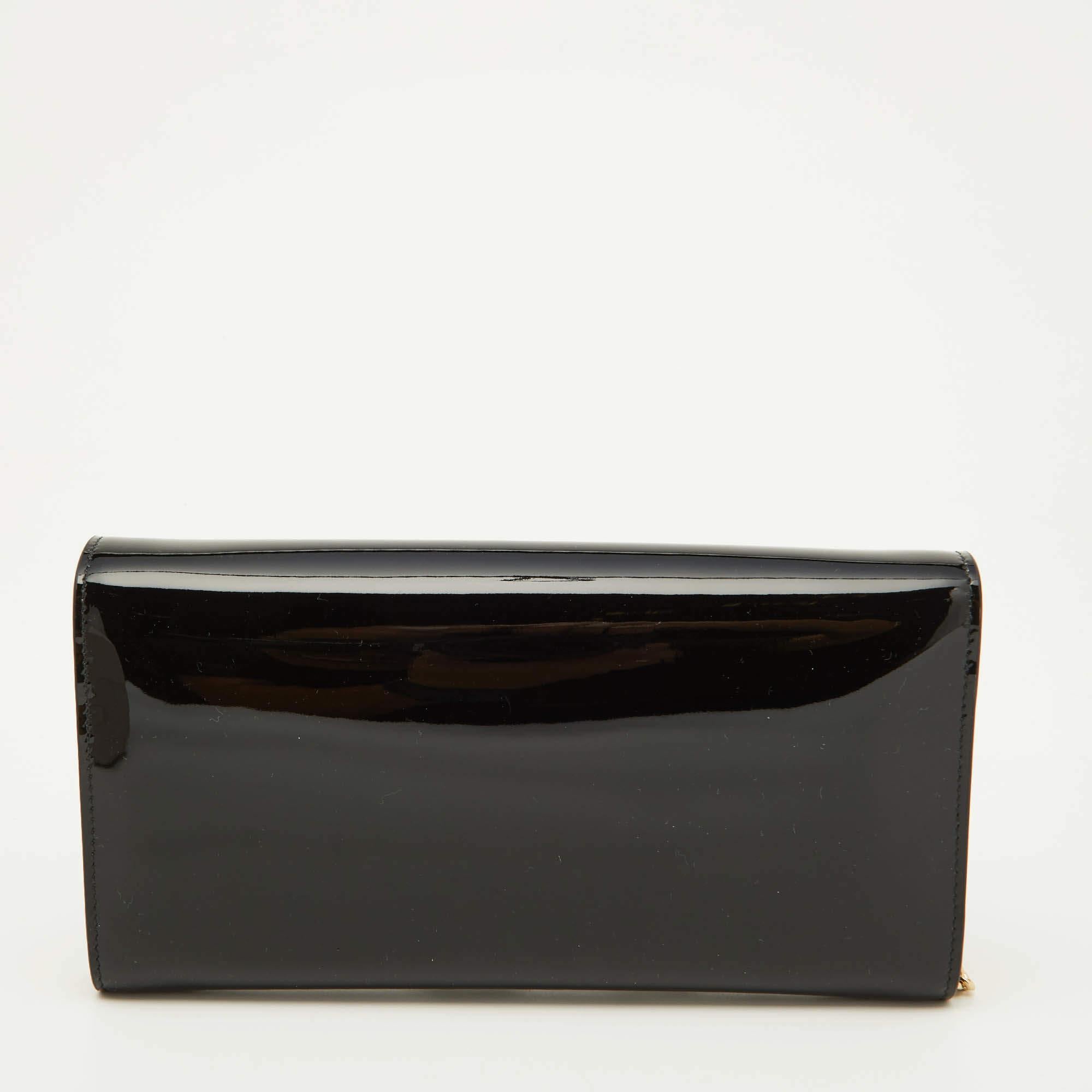 This clutch from Jimmy Choo has an appealing design, perfect to complement an evening dress or a day ensemble. The design involves a black patent leather exterior paired with gold-tone hardware to create an alluring display. A chain completes