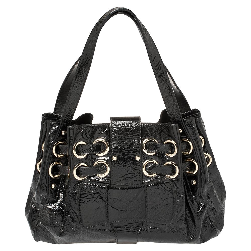 Die beliebte Ramona ist eine weitere perfekt gestaltete und praktische Handtasche des Luxuslabels: Jimmy Choo. Sie ist aus schwarzem Lackleder gefertigt und mit doppelten Kordelzügen und großen Ösen:: einem gravierten Jimmy Choo-Schnallenverschluss