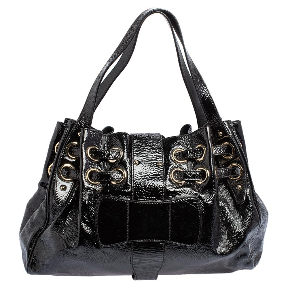 The popular Ramona is another perfectly designed and practical handbag from Jimmy Choo. Crafted from black patent leather, it is accented with double drawstrings and large grommets, a logo-engraved flip lock, and dual shoulder handles. The interior