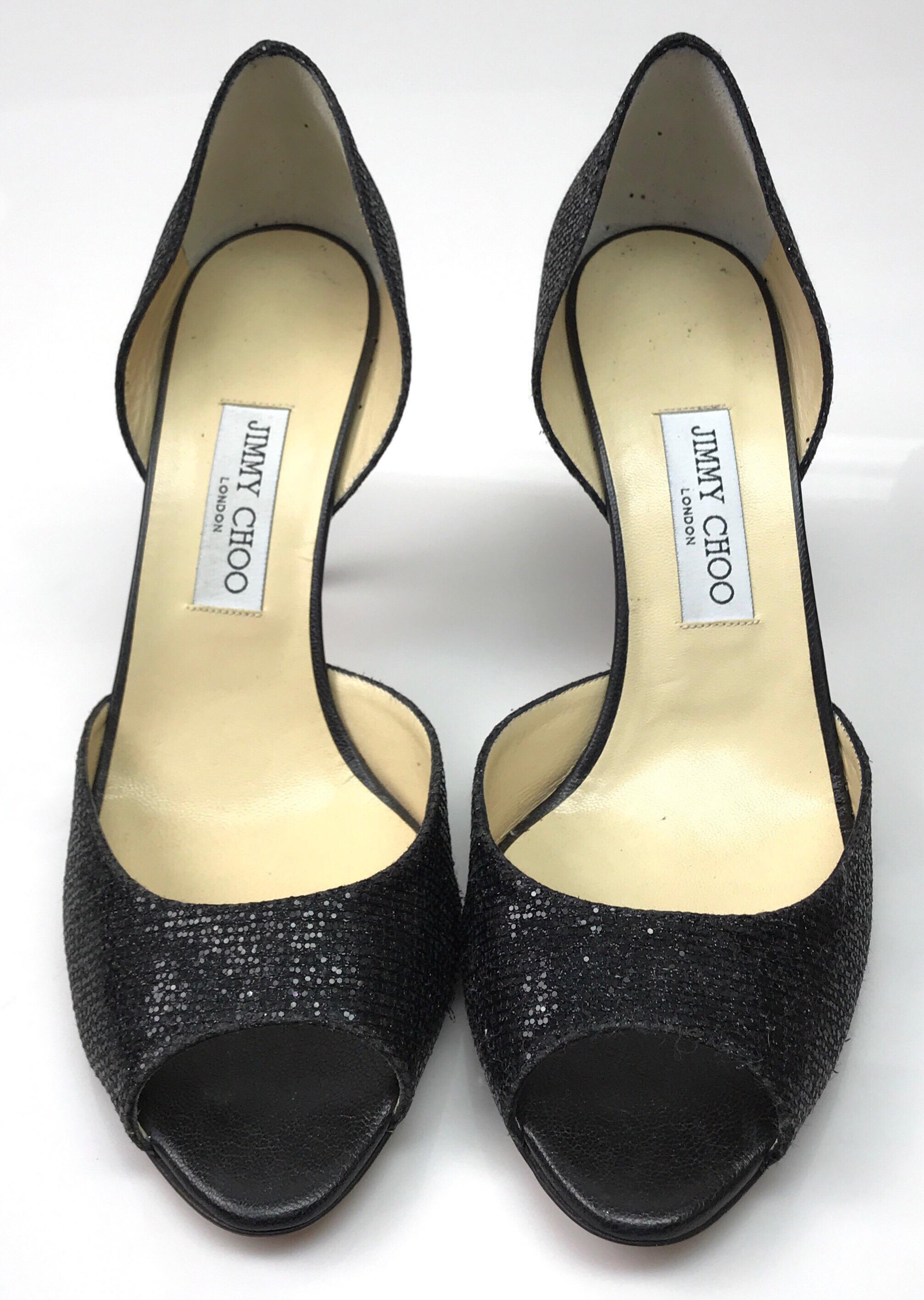Jimmy Choo Black Peep Toe Sparkle Heels - 42. These elegant Jimmy Choo heels are in good condition. There is use consistent with wear, as shown in pictures. These peep toe heels are made of black sparkles throughout. The heel has a black leather