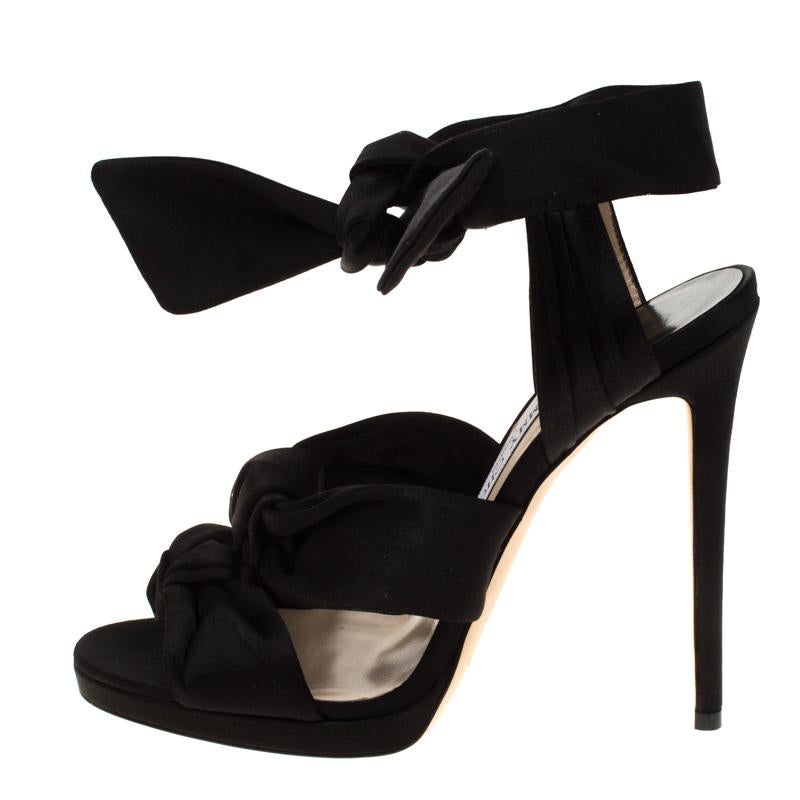 Sing the tune of the season with this gorgeous pair of sandals from Jimmy Choo. They are styled with satin straps in knots that add a modern touch. Thin platforms, ankle ties, and slim 13 cm high stiletto heels make the sandals ready to be worn by