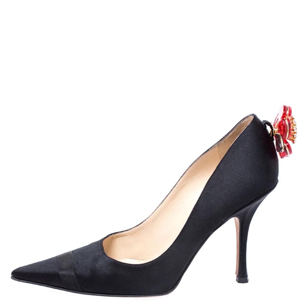 This pair of Jimmy Choo pumps is a style statement and a timeless piece. Sporting a fine satin exterior, these pumps are designed with pointed toes, high heels and flower applique on the counters. Subtle and stylish, this pair of black pumps win you