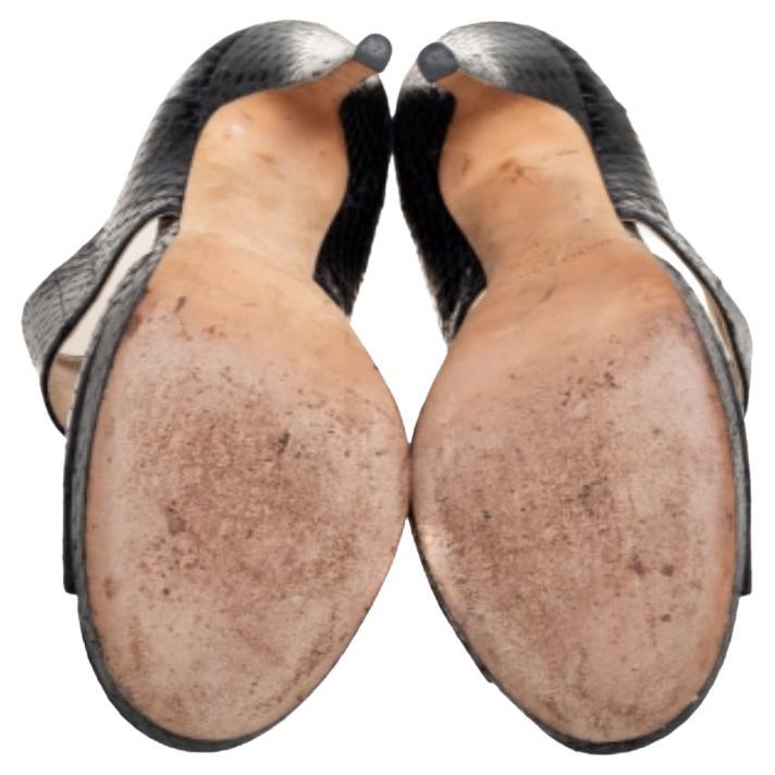 Cette chic paire de sandales privées pour les fêtes de Jimmy Choo est tout ce dont vous avez besoin. Il est confectionné dans une magnifique peau de serpent et doté de larges brides sur les empeignes et les chevilles. Les semelles intérieures sont