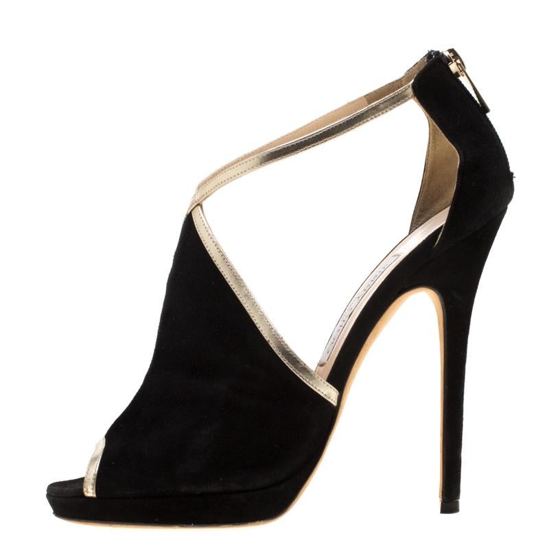 Elevate your style quotient by wearing this pair of Fey pumps from Jimmy Choo. Crafted from black suede, they feature a peep-toe silhouette. The wide vamp covering is accented with gold leather trims. They come with zip-up fastenings at the counters